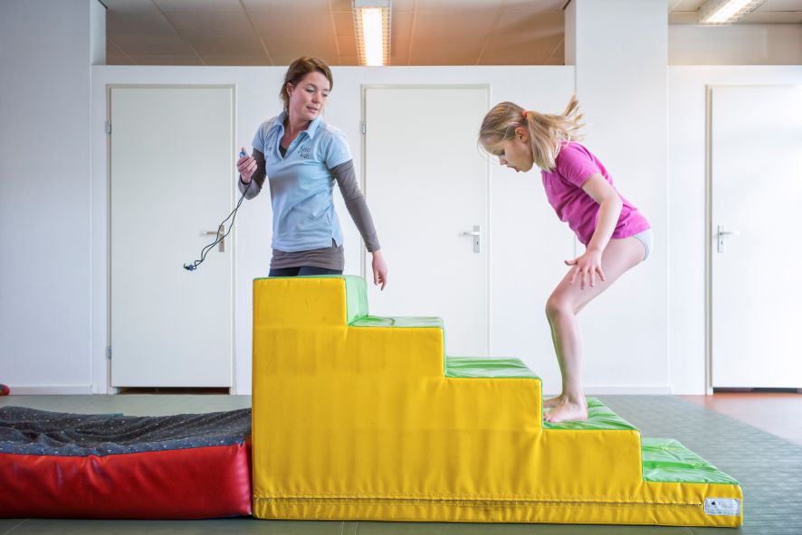 Therapeut en kind oefenen op blokken